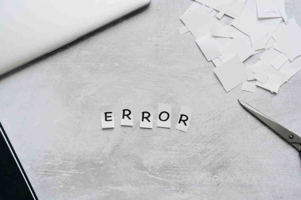 Reasons Shopify Stores Fail: paper letters spelling ERROR next to scissors on a grey surface