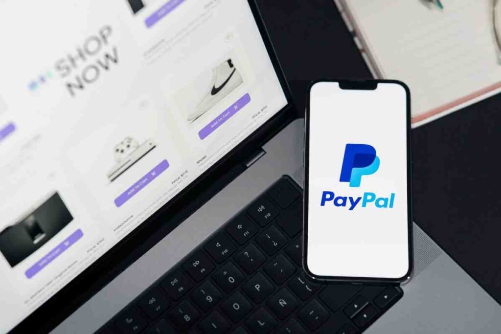 Best Payment Gateways Online Store: PayPal app on a smartphone beside a laptop showing a shop page