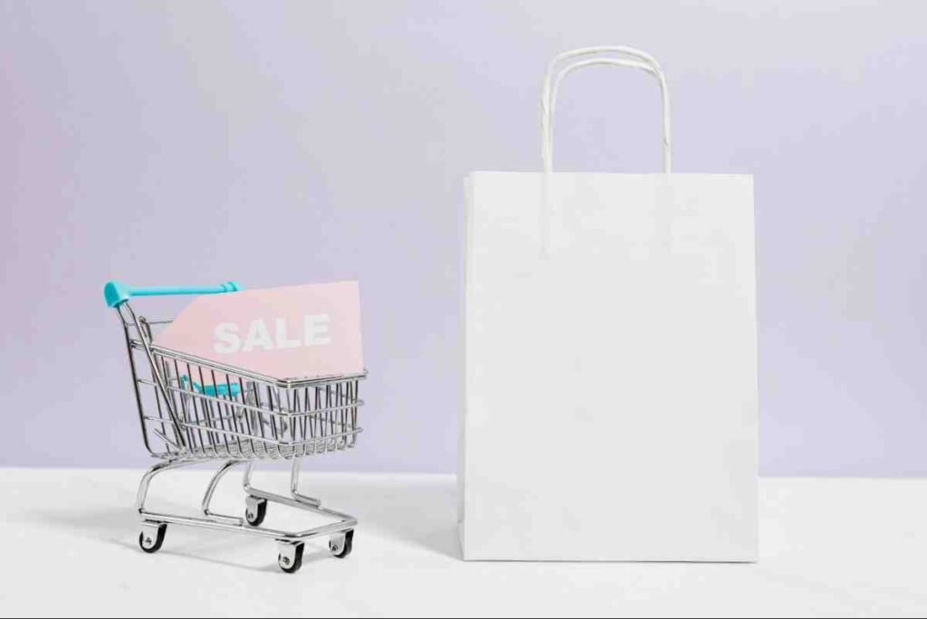 Ecommerce Store Case Study concept with a mini shopping cart, sale sign and white paper bag