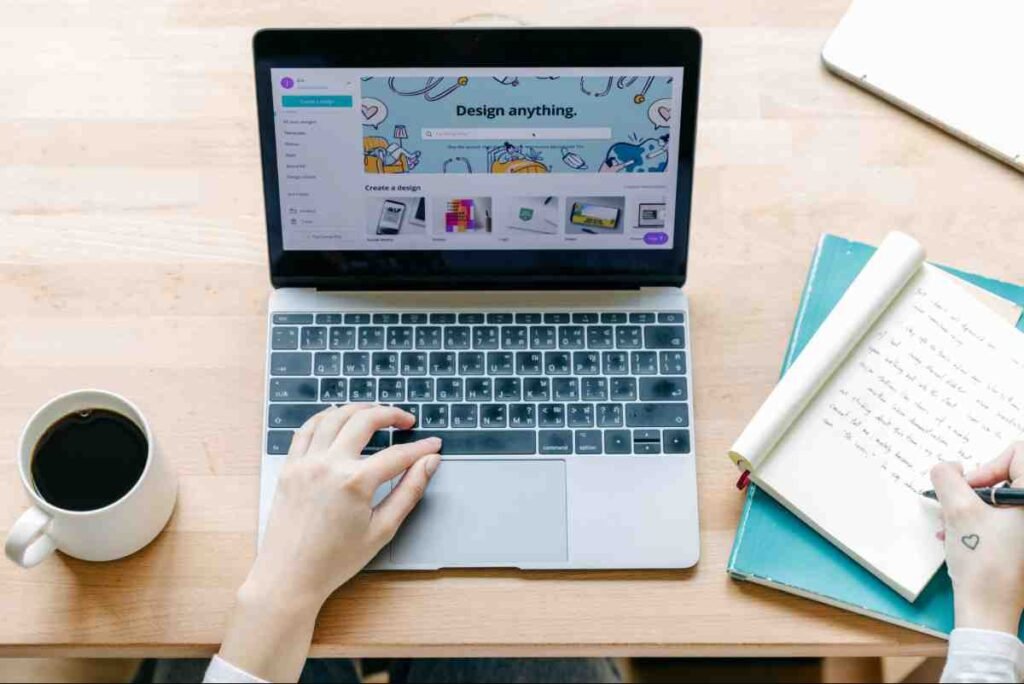 How to write SEO friendly blog posts: person working on a laptop while taking notes at a wooden desk
