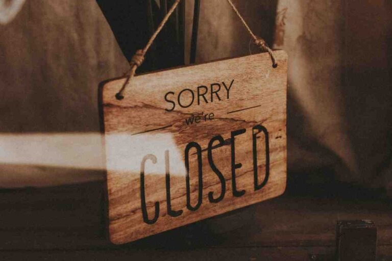 Reasons Shopify Stores Fail: wooden "Sorry we're closed" sign hanging on a rope