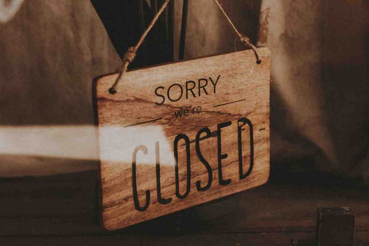 Reasons Shopify Stores Fail: wooden "Sorry we're closed" sign hanging on a rope