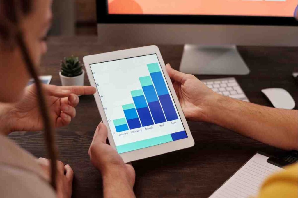 Team analyzing monthly growth chart on tablet – Competitor SEO Analysis Guide