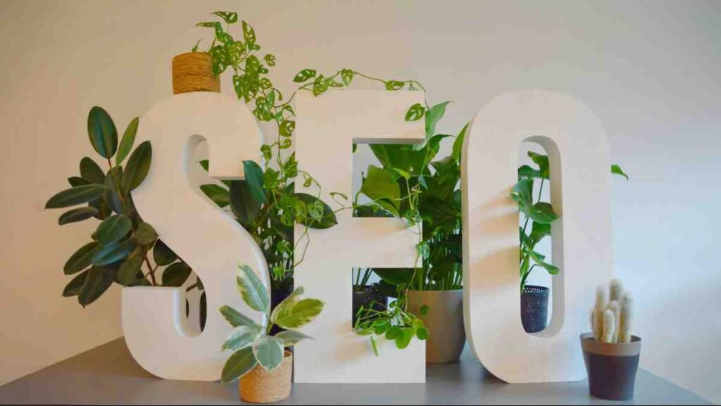 White SEO letters surrounded by green plants showing how to fix duplicate content SEO for growth
