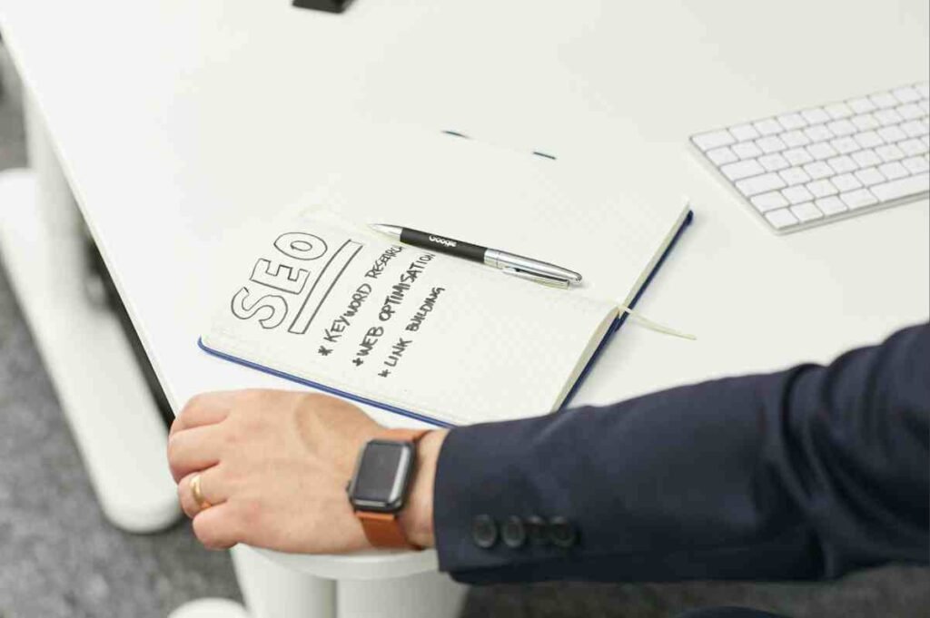 Notebook with SEO plan notes beside a keyboard, a useful start for the SEO vs PPC small business decision